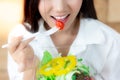 Attractive woman is eating vegetables or tomato by using fork. C Royalty Free Stock Photo